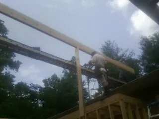 Carpenter setting a ridge beam over a new addition frame — Ice Dam Removal by Roofing Brothers in Hodges